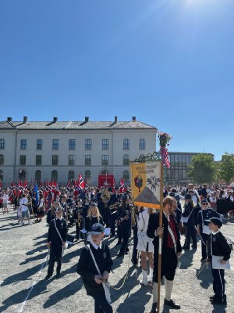 En gruppe mennesker som marsjerer foran en bygning