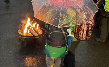 en person som holder en paraply over et bål